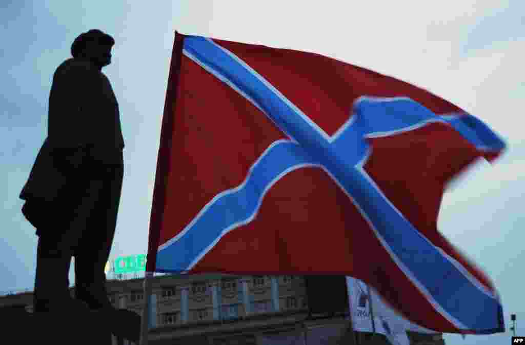 The "New Russia" (Novorossia) flag flies next to the statue of Soviet founder Vladimir Lenin on Lenin Square in the eastern Ukrainian city of Donetsk. (AFP/Dominique Faget)
