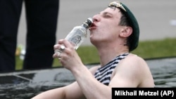 A Russian man celebrates Border Guards Day by drinking vodka in a public fountain in Moscow. (file photo)