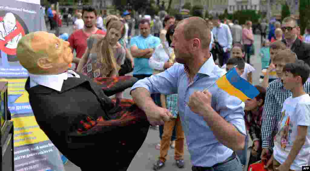 Ukrainanyň Lwow şäherinde geçip barýan bir adam rus prezidenti Wladimir Putiniň şeklini ýumruklaýar.