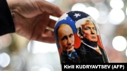 A vendor shows a traditional Russian wooden nesting doll depicting Vladimir Putin and Donald Trump at a gift shop in central Moscow. (file photo)