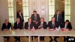 Президент України Леонід Кравчук (другий ліворуч), голова Верховної Ради Білорусі Станіслав Шушкевич (третій ліворуч) і президент Росії Борис Єльцин (другий праворуч) під час підписання Біловезької угоди, 8 грудня 1991 року