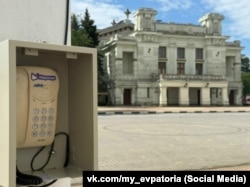 Таксофон в Евпатории, установленный местными российскими властями для связи людей с экстренными службами во время энергетического кризиса в регионе, июль 2026 года