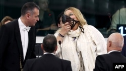 Diana Iovanovici-Sosoaca (center) wears a muzzle surrounded by bailiffs as she is escorted out of the European Parliament in Strasbourg on July 18.