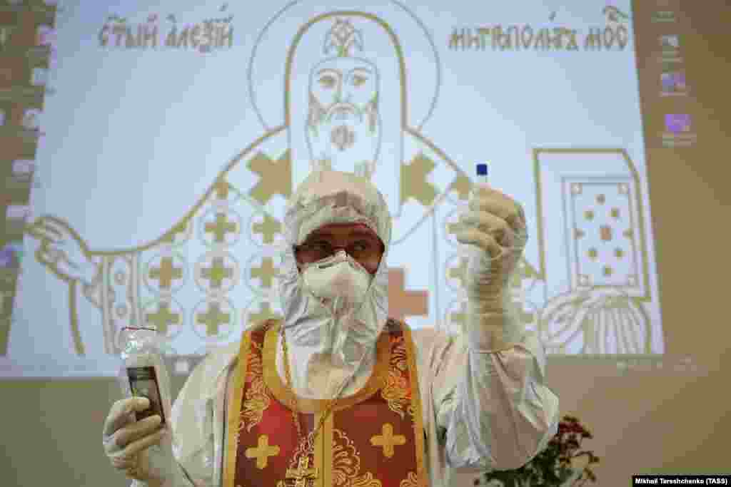 Archpriest Ioann Kudryavtsev shows a disposable vial of consecrated oil during a lecture titled Pastoral Counseling Amid the Pandemic -- PPE Use And Spiritual Guidance Of COVID-19 Patients at St. Aleksii Hospital Metropolitan of Moscow Hospital on April 20. (TASS/Mikhail Tereshchenko)