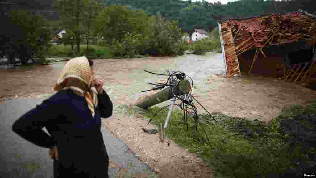 A woman stands near a river and looks at a house that was destroyed during floods in Potocari near Srebrenica, Bosnia-Herzegovina, on May 25. (Reuters/Dado Ruvic)