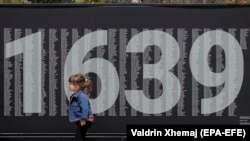 O fată trece pe lângă un panou cu numele persoanelor dispărute, atât albanezi, cât și sârbi în timpul războiul din 1998-99. Aproximativ 1639 de persoane sunt încă date dispărute.