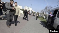 Қарапайым адамша киінген полиция қызметкерлері журналистерді тұтқындап жатыр. Минск, Беларусь 18 қыркүйек 2012 жыл.