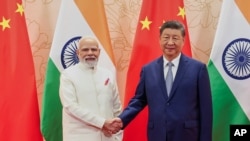 Kryeministri indian Narendra Modi, majtas, dhe presidenti kinez Xi Jinping, shtrëngojnë duart para takimit të tyre në margjinat e samitit të Organizatës së Bashkëpunimit të Shangait (SCO) në Tianjin të Kinës, 31 gusht 2025.