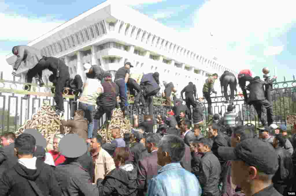 Участники митинга в поддержку национализации золоторудного месторождения "Кумтор" перелезают через забор здания парламента