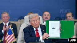 Президент США Дональд Трамп показує підписаний документ під час саміту щодо Гази в Шарм-еш-Шейху 13 жовтня 2025 року.
