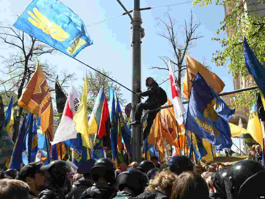 Прихильники опозиції скандують «ганьба!». Вони тримають партійні прапори «Нашої України», ВО «Свобода» та БЮТ.