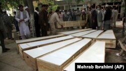 The coffins of the victims of the June 8 attack are placed on the ground at a hospital in northern Baghlan Province on June 9.