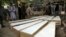 The coffins of the victims of the June 8 attack are placed on the ground at a hospital in northern Baghlan Province on June 9.