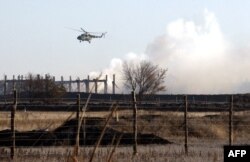 Український вертоліт пролітає над пожежою на військовому кладі у місті Сватове Луганської області. 30 жовтня 2015 року