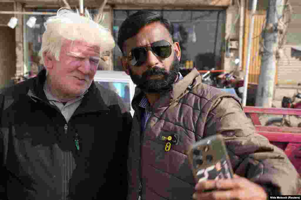 Saleem Bagga, seen by some as a lookalike of U.S. President-elect Donald Trump, poses for a selfie with a customer while selling kheer, a traditional South Asian rice pudding, along a road in Sahiwal, Pakistan.&nbsp;