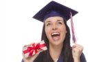 Shutterstock. Happy Female Graduate in Cap and Gown Holding Stack of Gift Wrapped Hundred Dollar Bills.
