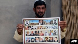 An Afghan man holds a calendar bearing the images of Afghan leaders including the Taliban's late chief Mullah Omar in Kandahar in July 2015. 