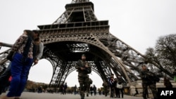 Вооруженные солдаты стоят у Эйфелевой башни. Париж, 14 ноября 2015 года.