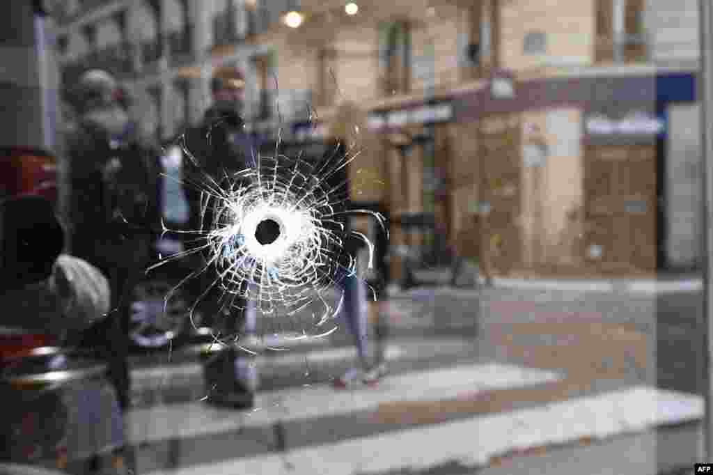 A bullet hole is shown on the window of a cafe located at the crossroads between the streets Saint-Augustin and Monsigny on May 13 in Paris, the day after a knifeman killed one man and wounded four other people. (AFP/Eric Feferberg)