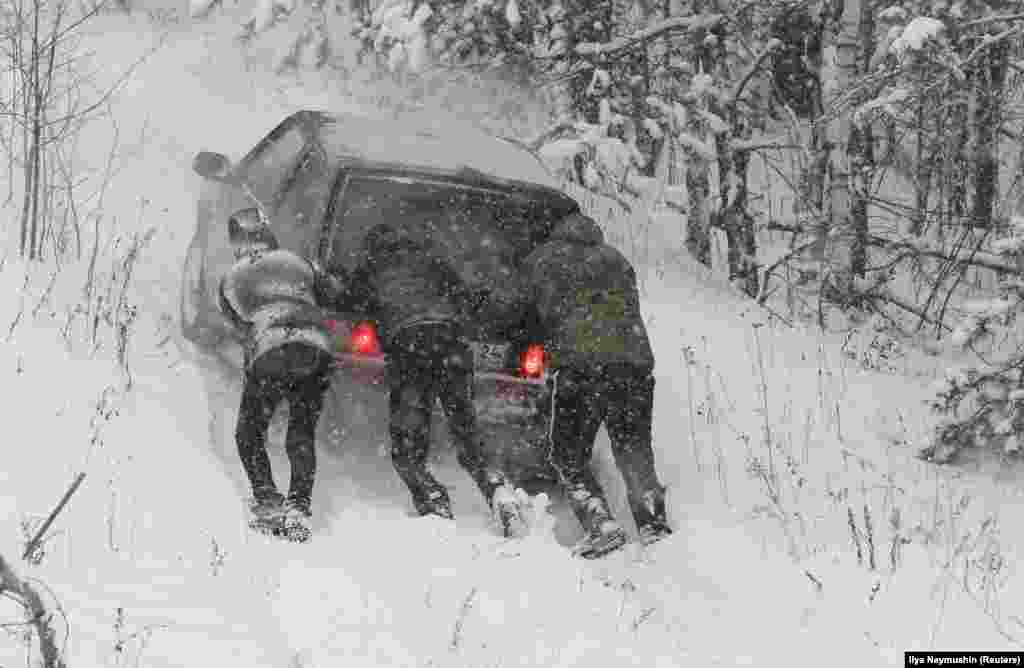 Men push a car during a snowfall in the Siberian taiga area outside Krasnoyarsk, Russia. (Reuters/Ilya Naymushin)