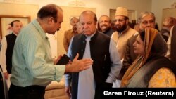 Former Pakistani Prime Minister Nawaz Sharif (center) speaks with members of his former cabinet as he prepares to leave Punjab house in Islamabad on August 9.