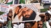 FILE: Indian Muslims hold a scratched photo of Jaish-e Mohammad group chief Masood Azhar, as they protest against Pakistan in Mumbai on February 15.