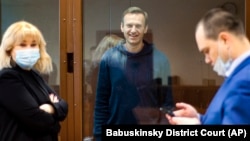 Russian opposition leader Aleksei Navalny smiles as he talks with his lawyers during a court hearing in Moscow last month.