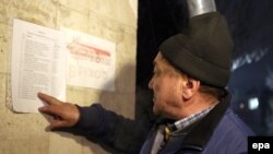 Мужчина читает список с именами погибших в результате крушения под Бишкеком самолета «Боинг 747-400F». 
