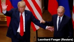 U.S. President Donald Trump (left) and Russian President Vladimir Putin react at the end of their joint news conference after their summit in Helsinki on July 16.