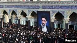 A large, likely AI-generated image of Iran's Supreme Leader Mojtaba Khamenei is shown during a ceremony to honor his father, slain Supreme Leader Ayatollah Ali Khamenei, in Qom on July 7.