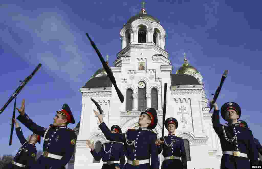 Cossack cadets toss their rifles as they practice for an upcoming performance outside a cathedral in the southern Russian city of Novocherkassk. (Reuters/Vladimir Konstantinov)