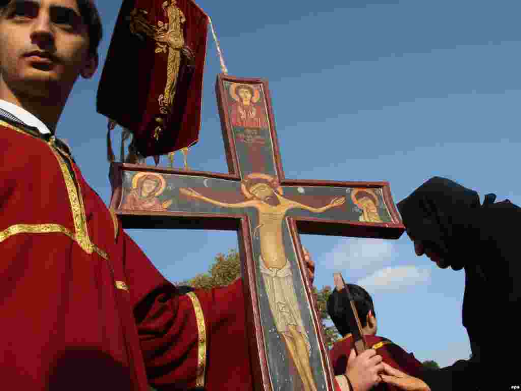 A Georgian boy holds a cross in an annual service in Tbilisi for Georgian Christians who have died for their faith. - Photo by Zurab Kurtsikidze for epa