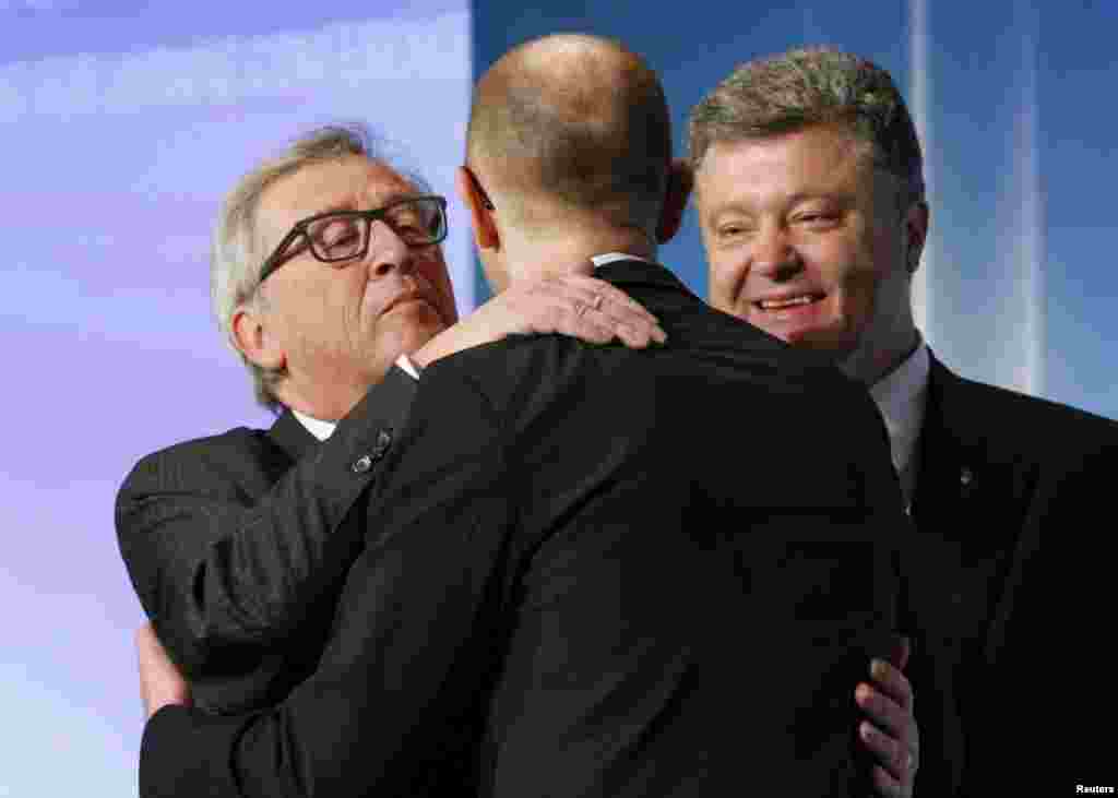 European Commission President Jean-Claude Juncker (left) embraces Ukrainian Prime Minister Arseniy Yatsenyuk as President Petro Poroshenko (right) stands by during the International Support for Ukraine conference in Kyiv on April 28. (AFP/Sergei Gapon)