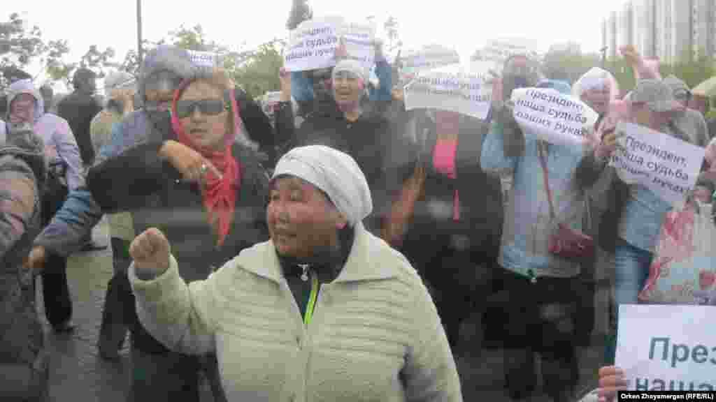 После задержания нескольких людей оставшиеся активисты движения &laquo;ипотечников&raquo; развернули свои плакатики и начали скандировать лозунги с просьбой к президенту Казахстана Нурсултану Назарбаеву помочь им. Астана, 22 мая 2013 года.