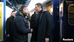 Spanish Prime Minister Pedro Sanchez (right) is greeted by Ukrainian officials upon his arrival in Kyiv on February 23. 