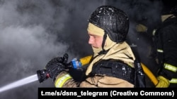 Рятувальник гасить пожежу на місці російського удару, фото ілюстративне