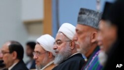 In this photo released by official website of the office of the Iranian Presidency, President Hassan Rouhani, center, attends an annual Islamic Unity Conference in Tehran, Iran, Saturday, Nov. 24, 2018. Rouhani has called Israel a "cancerous tumor" establ