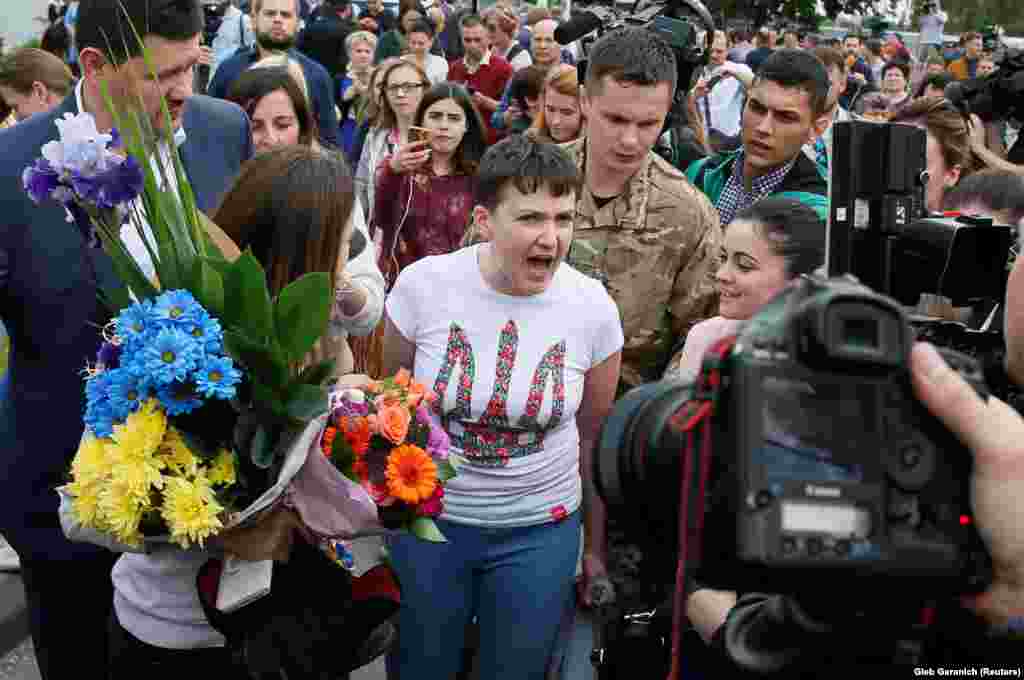 Украинская военнослужащая Надежда Савченко говорит с журналистами в аэропорту Борисполь в Киеве 25 мая. Савченко была захвачена на востоке Украины в июне 2014 года и тайно перевезена в Россию, где ей предъявили обвинения в пособничестве убийству двоих российских журналистов. Ее обменяли на двоих российских заключенных на Украине. (Reuters/Gleb Garanich)