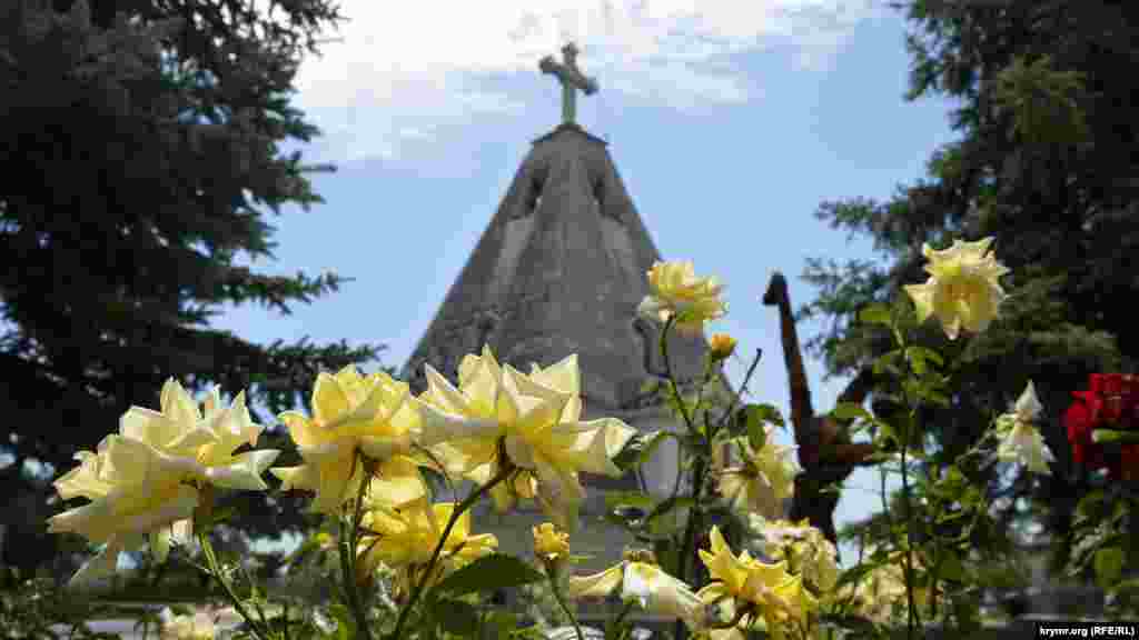 Возле церковной лавки цветут розы и кактусы-опунции