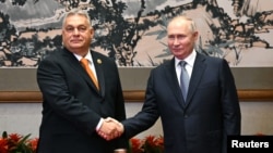 Russian President Vladimir Putin (right) and Hungarian Prime Minister Viktor Orban shake hands at a meeting in Beijing earlier this month. 