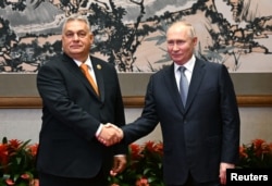 Orban shakes hands with Russian President Vladimir Putin during a meeting ahead of the Belt and Road Forum in Beijing on October 17.