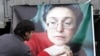 A Russian man lays flowers near the picture of murdered journalist Anna Politkovskaya during a rally in Moscow on the anniversary of her death in 2009.