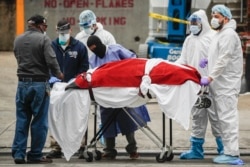Медики транспортируют тело одного из умерших в нью-йоркском районе Бруклин