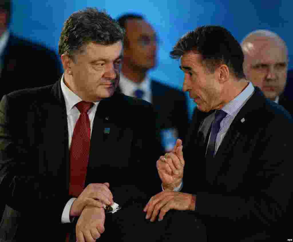 Лидеры стран - членов НАТО на саммите в Уэльсе 5 сентября заявили о поддержке Украины. Они согласовали создание трастовых фондов в поддержку обороноспособности Украины и для нужд военнослужащих украинской армии, получивших ранения в ходе продолжающегося пятый месяц вооружённого противостояния в Донбассе. Лидеры США и стран ЕС заявили, что против Москвы будут объявлены санкции в ответ на значительное увеличение ею за последние дни военной поддержки воюющим на востоке Украины пророссийским сепаратистам. На фото: президент Украины Петр Порошенко и генеральный секретарь НАТО Андрес Фог Расмуссен (справа).