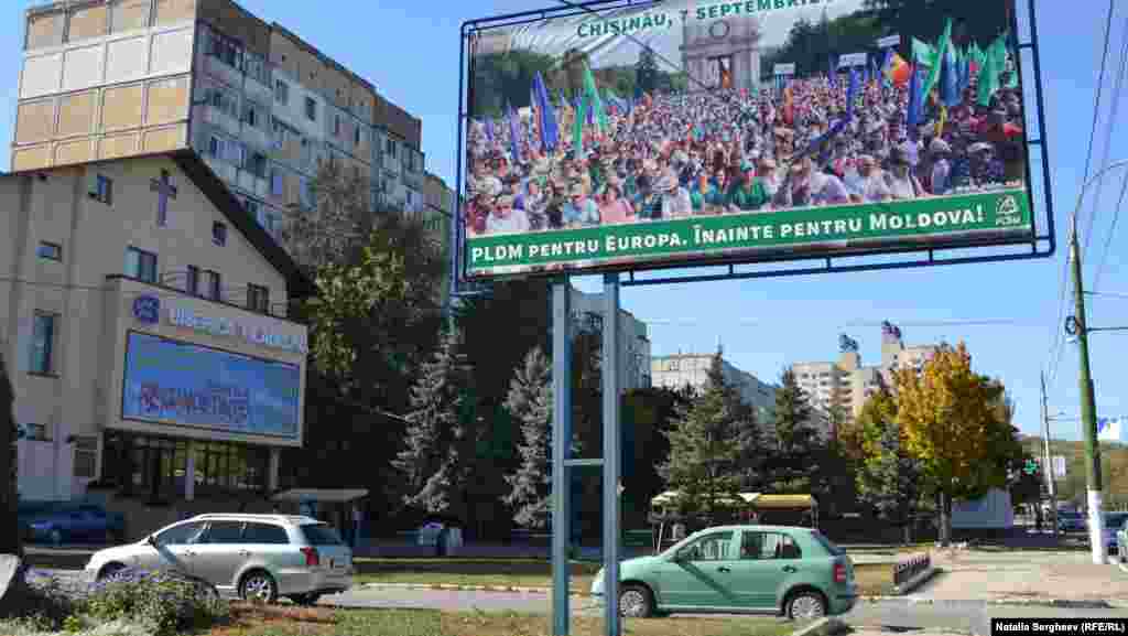 Publicitatea electorală a Partidului Liberal Democrat din Moldova, în apropierea unei biserici 