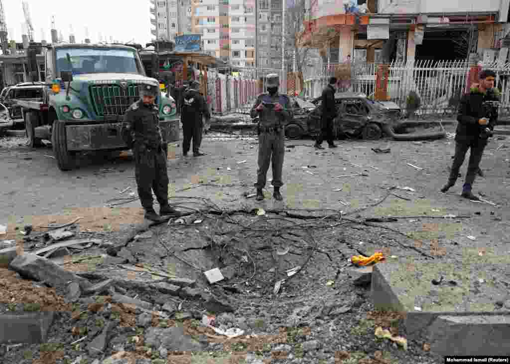 Afghan policemen inspect the site of the blast, which President Ashraf Ghani blamed on &quot;the enemies of Afghanistan.&quot;