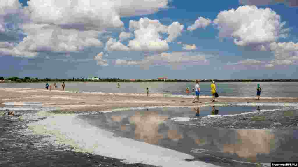 Курортники на пенистом берегу Мойнакского озера