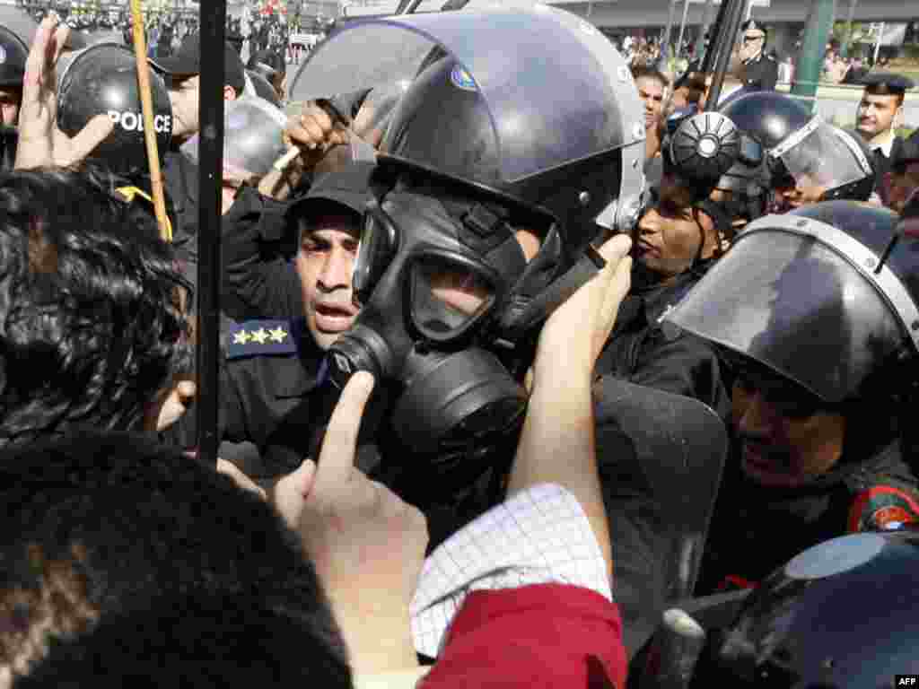 A demonstrator confronts a riot policeman wearing a gas mask after Friday Prayers in Cairo on January 28.