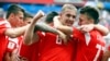 Russia's Yury Gazinsky celebrates with teammates after scoring his side's first goal during the group A match between Russia and Saudi Arabia.