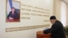 Шавкат Мирзияевтің суреті ілініп тұрған учаскеде дауыс беріп жатқан тұрғын. Өзбекстан, 22 желтоқсан 2019 жыл.